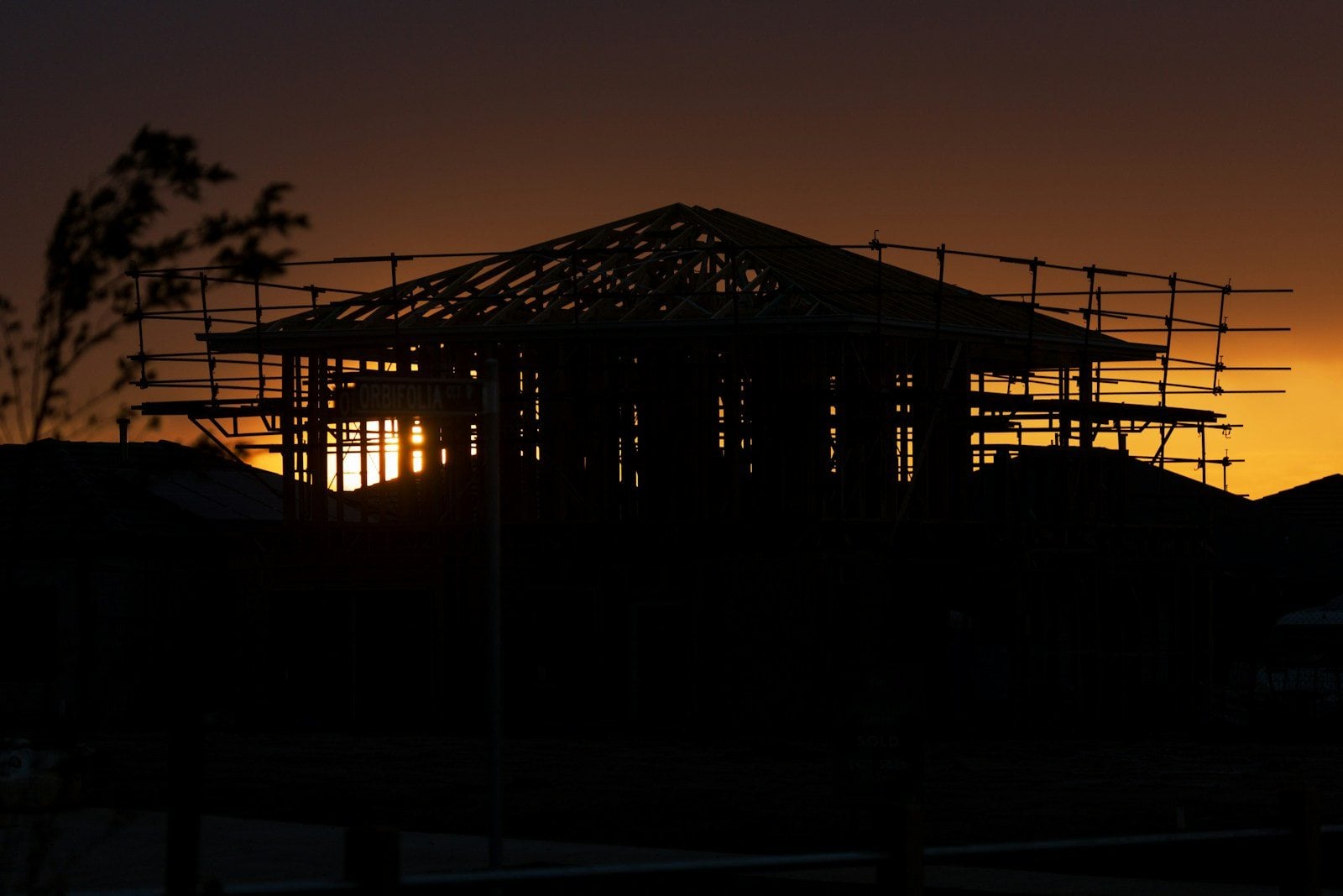 A house frame against an orange evening sky